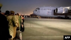 19일 아프가니스탄 카불의 공군기지에서 미군 수송기에 타려는 사람들이 줄 서 있다.