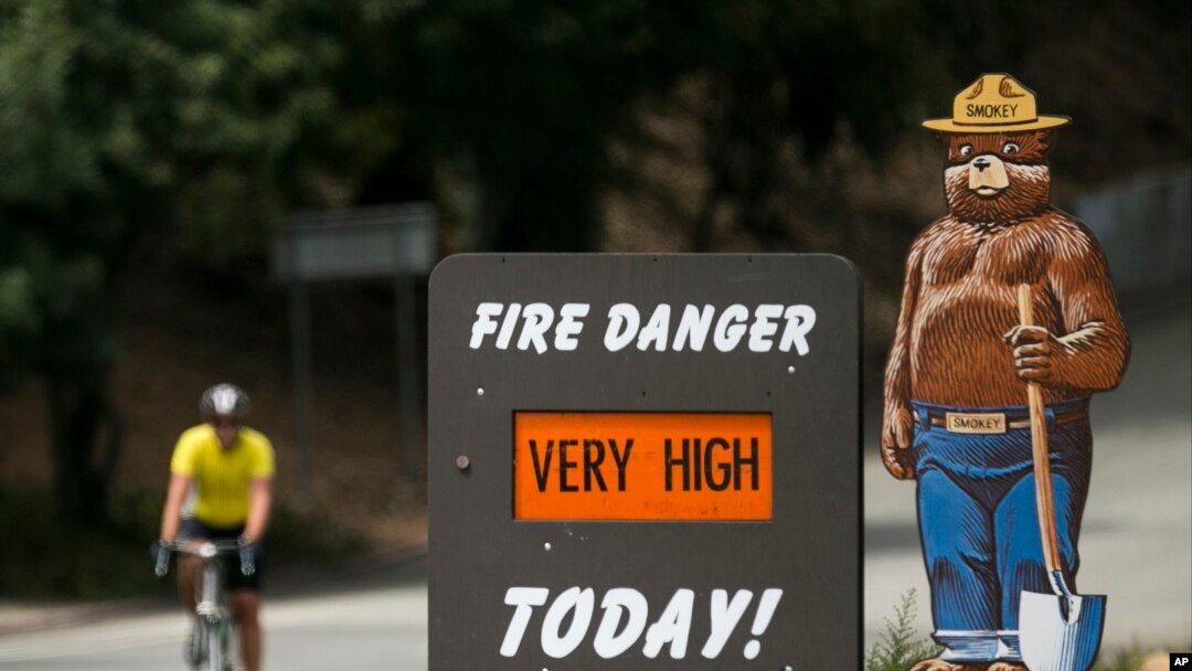 FILE - A Smokey Bear "Very High" fire danger sign is posted at the entrance to Griffith Park in Los Angeles, Sept. 10, 2015. 