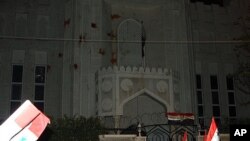 Pro-Syrian regime protesters, gather and shout slogans against the Arab League as they throw tomatoes at the Qatari embassy during a protest, in Damascus, Syria, November 12, 2011.