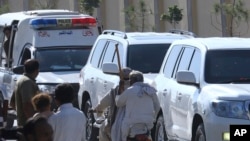 People watch a convoy carrying Bushra Bibi, wife of Pakistan's imprisoned former Prime Minister Imran Khan, leave following her release from prison a day after a court granted her bail in a graft case, in Rawalpindi, Pakistan, Oct. 24, 2024.