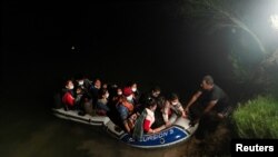 Una familia en busca de asilo en EE. UU. llega en una balsa inflable a la localidad de Roma, Texas, tras cruzar el Río Grande, el 10 de junio de 2021.