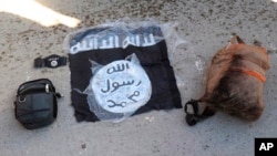 This photo provided by the Kurdish-led Syrian Democratic Forces shows the flag and bags of Islamic State group fighters arrested by the SDF after they attacked al-Sina’a Prison, in Hasakah, Syria, Jan. 21, 2022. 