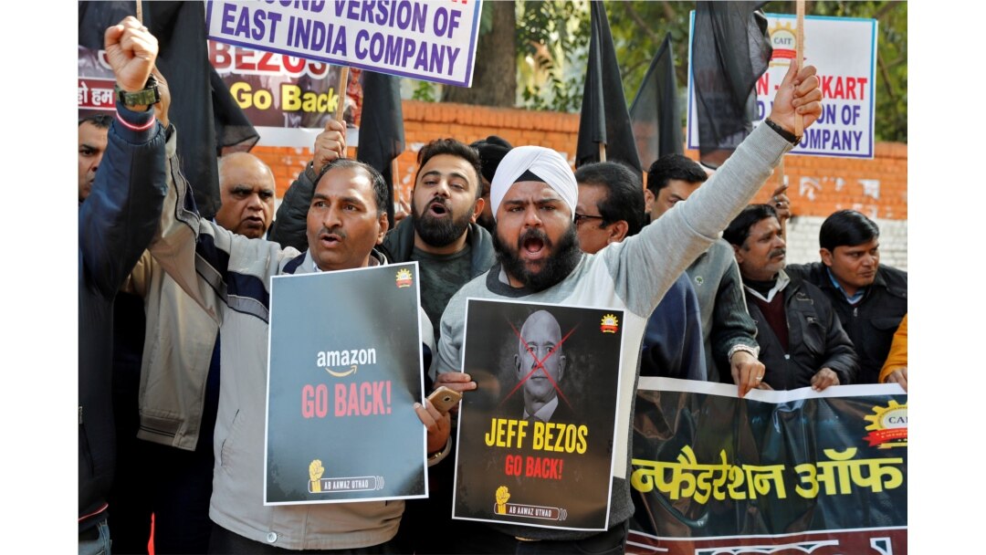 Members of the Confederation of All India Traders (CAIT) hold placards and shout slogans during a protest against the visit of Jeff Bezos, founder of Amazon, to India, in New Delhi, Jan. 15, 2020.