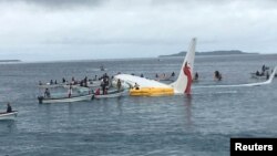 People are evacuated from an Air Niugini plane crashed in the waters in Weno, Chuuk, Micronesia, in this picture obtained from social media. 