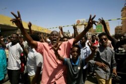 People shouting slogan gather near the scene of an explosion that targeted the motorcade of Prime Minister Abdallah Hamdok near the Kober Bridge in Khartoum, March 9, 2020.