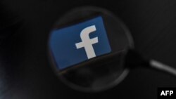 Facebook, whose logo is seen on a smartphone in this file photo, said Wednesday that it is aware of outages on its platforms including Facebook, Messenger and Instagram.