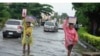 FILE - Women walk along a flooded street after a heavy downpour in Lagos, Nigeria, on July 10, 2024.