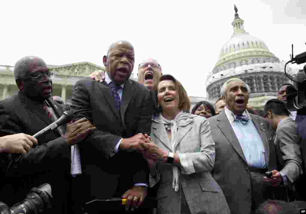 Dari kiri ke kanan, para anggota DPR dari Partai Demokrat James Clyburn, John Lewis, Joseph Crowley, Nancy Pelosi, dan Charles Rangel, menyanyikan &quot;We Shall Overcome&quot; di luar Gedung Capitol di Washington (23/6).