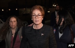 Former U.S. Ambassador to Ukraine Marie Yovanovitch, center, flanked by lawyers, aides and Capitol police, leaves the Capitol, Oct. 11, 2019, in Washington, after testifying to the House Intelligence, Foreign Affairs and Oversight committees.