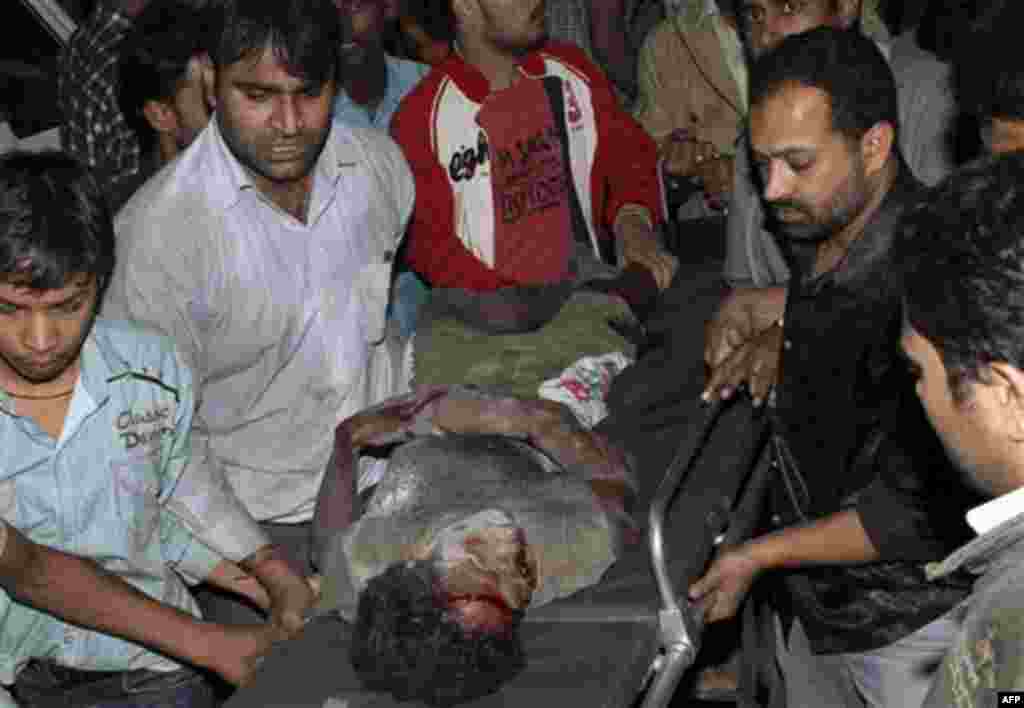 An injured Indian man is helped at the scene of a building collapse in New Delhi, India, late Monday Nov. 15, 2010. An unknown number of people are believed dead and injured in the incident after a four-storey building collapsed in a neighborhood in easte