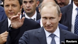 FILE - Russian President Vladimir Putin, followed by Italian Prime Minister Matteo Renzi, left, visit the Expo 2015 global fair in Milan, northern Italy, June 10, 2015.