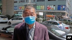 FILE - Pro-democracy media tycoon Jimmy Lai arrives at a police station in Hong Kong.