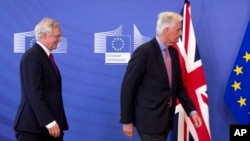 Ketua perunding Inggris David Davis (kiri) dan perunding Uni Eropa Michel Barnier siap memberikan pernyataan kepada media di Brussels, Senin (19/6). 