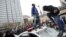 Protesters jump on a police car at a rally to protest the death of Freddie Gray who died following an arrest in Baltimore, April 25, 2015. 