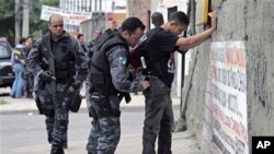 A policeman frisks a man during an operation against drug traffickers at the Complexo de Alemao slum in Rio de Janeiro,26 Nov 2010