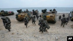 FILE - South Korean marines run out from amphibious assault vehicles after landing on the beach during a combined military amphibious landing exercise between South Korea and the U.S., in Pohang, South Korea, Sept. 2, 2024.