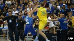 Dalam foto 2 Juli 2018, Matthew Wright (kiri) dari Filipina dan Daniel Kickert dari Australia beradu tinju dalam perkelahian yang terjadi saat berlangusng laga penyisihan Asia Piala Dunia FIBA di area Filipina di Kota Bocaue, Provinsi Bulacan, utara Manila. Federasi Basket Internasional (FIBA) menjatuhkan sanksi berat kepada timnas Filipina akibat perkelahian tersebut pada 19 Juli 2018. (Foto: AFP)
