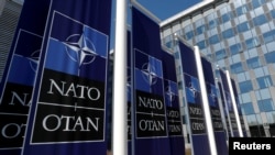 FILE - Banners displaying the NATO logo are seen at the entrance of NATO headquarters in Brussels, Belgium, Apr. 19, 2018.