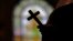 FILE - A silhouette of a crucifix is seen against the backdrop of a stained glass window inside a Catholic Church in New Orleans, Louisiana, Dec. 1, 2012.