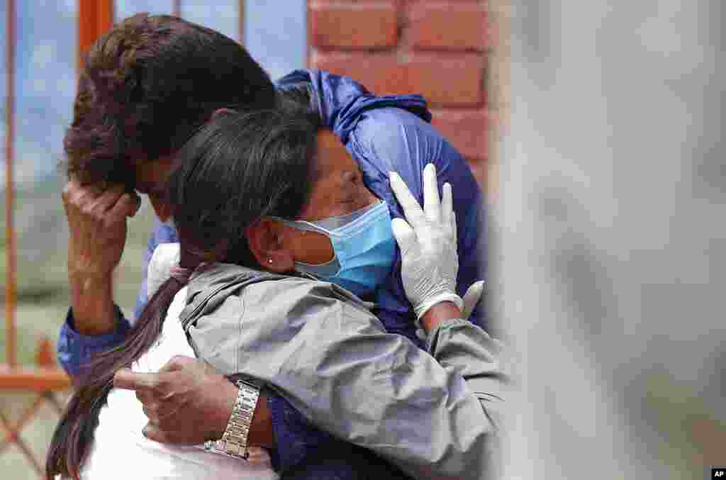 Relatives of a person who died of COVID-19 mourn at a crematorium in Kathmandu, Nepal, after an infection surge prompted the government to impose new lockdowns in major cities and towns.