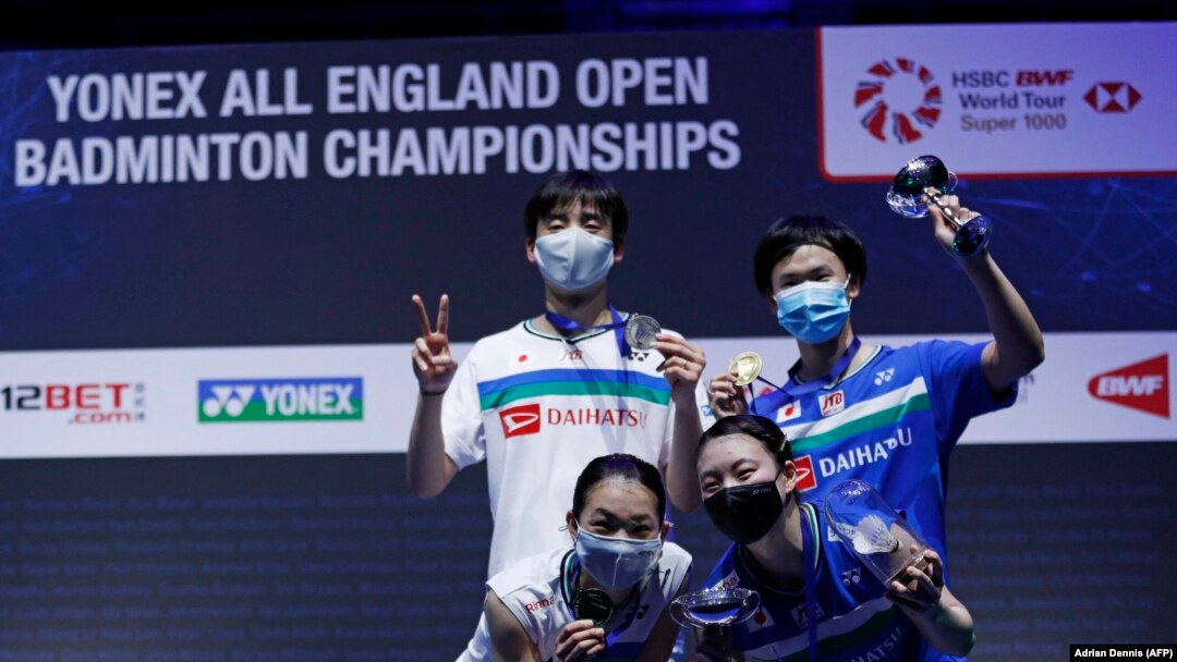 Pemenang ganda campuran turnamen All England Yuta Watanabe (kanan) dan Arisa Higashino (kanan) berpose di podium bersama juara dua, Yuki Kaneko (kiri (belakang) dan Misaki Matsumoto (kiri depan), di Arena Utilita, Birmingham, Minggu, 21 Maret 2021.