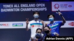 Pemenang ganda campuran turnamen All England Yuta Watanabe (kanan) dan Arisa Higashino (kanan) berpose di podium bersama juara dua, Yuki Kaneko (kiri (belakang) dan Misaki Matsumoto (kiri depan), di Arena Utilita, Birmingham, Minggu, 21 Maret 2021.