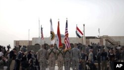 Tutar Amurka, da ta Iraqi da ta Rundunar Sojojojin Amurka a Iraqi a wurin bukin ayyana kawo karshen yakin Iraqi kafin a saukar da tutar Rundunar Sojojin Amurka a Iraqi, Alhamis 15 Disamba, 2011 a Bagadaza.