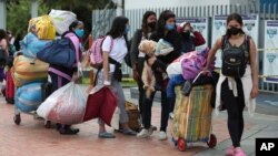 Migrantes venezolanos esperan un autobús para viajar a la frontera, luego de levantar el campamento en Bogotá, Colombia, el jueves 2 de julio de 2020.