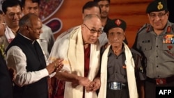 The Dalai Lama (center-left) shakes hands with Naren Chandra Das (center-right), the lone known survivor of a group of seven Indian guards who escorted the Tibetan spiritual leader into India nearly 60 years ago, in Guwahati, the capital of the northeastern Indian Assam state, April 2, 2017.