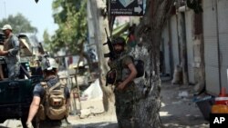 FILE - Members of Afghan security forces are seen during an operation in Jalalabad, Afghanistan, Aug. 3, 2020. Clashes in different parts of the country and a roadside bomb have killed about three dozen people Thursday.