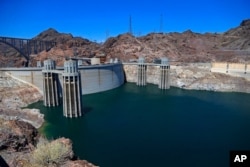 FILE - This May 31, 2018, photo shows the Hoover Dam impounding Lake Mead on the Colorado River near Boulder City, Arizona. (AP Photo/Ross D. Franklin, File)