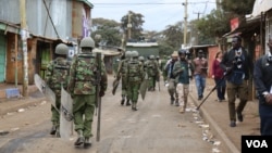 Kenyan police officers walk toward protesters in Nairobi’s Kibera slum, Aug. 12, 2017. Protests broke out following an announcement the previous night that President Uhuru Kenyatta had been re-elected. (J. Craig/VOA)