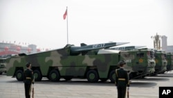 Chinese military vehicles carrying DF-17 ballistic missiles roll during a parade to commemorate the 70th anniversary of the founding of Communist China in Beijing, Tuesday, Oct. 1, 2019. Trucks carrying weapons including a nuclear-armed missile. (AP Photo/Mark Schiefelbein)