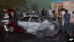 Warga setempat berkerumun di depan kendaraan yang sebagian terbakar setelah insiden penembakan di wilayah Tepito, Mexico City, Kamis 6 Juni 2013. (AP Photo). Tiga orang dilaporkan tewas dalam insiden tersebut.