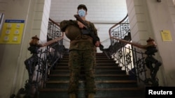 A soldier stands guard inside a polling station ahead of the upcoming presidential election in Santiago, Chile, Nov. 19, 2021. 