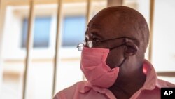 FILE - Paul Rusesabagina, whose story inspired the film 'Hotel Rwanda,' wears a pink prison uniform as he appears for a bail hearing at a court in Kigali, Rwanda, Sept. 25, 2020.