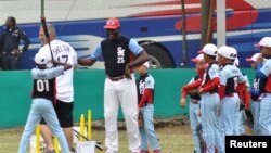 Tampa Bay Rays hitting coach Derek Shelton, left, and retired Cuban player Michel Ford (25) hold a baseball clinic for Cuban children the day before the Rays are to play an exhibition game against the Cuban National Team in Havana, Cuba, March 21, 2016. 