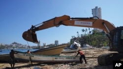 ARCHIVO - Residentes retiran un bote dañado tras la devastación que dejó el paso del huracán Otis, en Acapulco, México, el 12 de noviembre de 2023. 