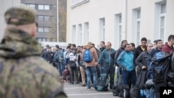 FILE - Asylum seekers queue up as they arrive at a refugee reception centre in the northern town of Tornio, Finland, on Friday Sept. 25, 2015. 