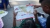 Migrants, who are part of a a caravan heading toward the country's northern border and ultimately the United States, check a map during a break, on the outskirts of Escuintla, southern Mexico, Nov. 7, 2024.