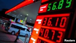 미국·이스라엘과 이란 간의 갈등이 이어지는 가운데, 태국 방콕의 한 주유소 앞에서 한 여성이 유가 전광판을 바라보고 있다.