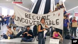 Des manifestants bloquent un escalator à l'aéroport de San Francisco, le 29 janvier 2017.