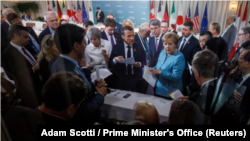 En la imagen, el primer ministro canadiense, Justin Trudeau, y los líderes del G7, la británica Theresa May, el francés Emmanuel Macron, la alemana Angela Merkel y el estadounidense Donald Trump, debaten en una cumbre del G7 en La Malbaie, Quebec, Canadá.