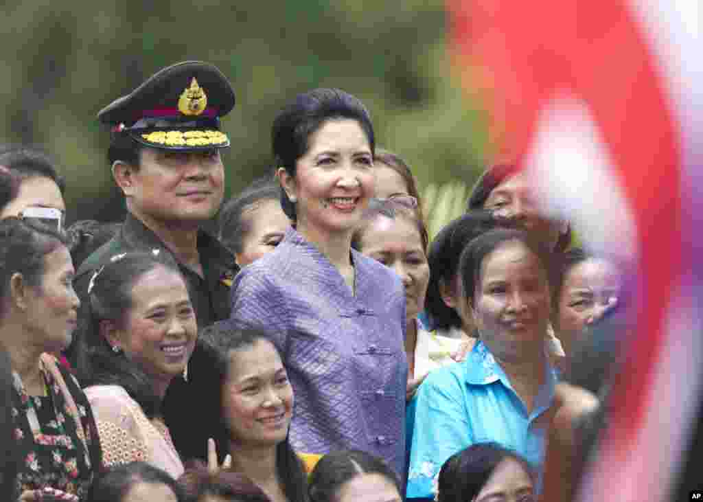 Prayuth Chan –Ocha and his wife Naraporn Chan–ocha pose with families of soldiers following his visit for an establishment anniversary of the 21st Infantry Regiment, Queen's Guard in Chonburi Province,Thailand.Thursday, Aug. 21, 2014.