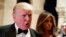 Melania Trump, right, looks on as her husband President-elect Donald Trump talks to reporters during a New Year's Eve party at Mar-a-Lago, Dec. 31, 2016, in Palm Beach, Florida. On Tuesday, Trump criticized the largest U.S. automaker for sending its Mexican-made Chevrolet Cruze compact models back to U.S. car dealers tax free.