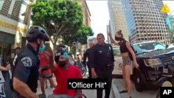 July 14, 2020 photo from police body camera video released by the Los Angeles Police Department shows a confrontation between officers and a man in a wheelchair hitting an officer in the face in what authorities say prompted his arrest.