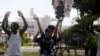 People rise their hands as they approach a police check point in Lagos, Nigeria, Thursday Oct. 22, 2020. Lagos streets were empty and shops were shuttered Thursday, as residents of Nigeria's largest city obeyed the government's curfew, stopping the…