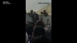 ԱՄՆ-ի զինվորականները աֆղանստանցի կնոջն օգնում են մագլցել Քաբուլի օդանավակայանի պատը