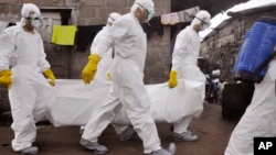 Children watch as health workers remove the body of a suspected Ebola victim in an area known as Clara Town in Monrovia, Liberia, Sept. 10, 2014. 