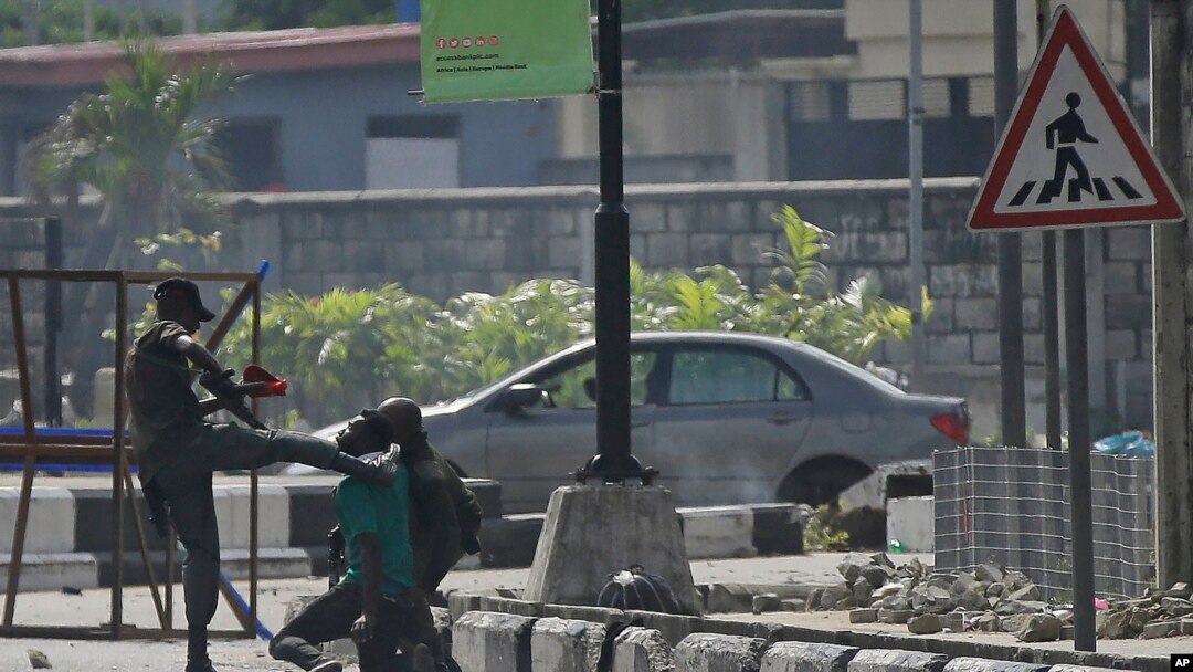 FILE - Police officers detain a protester at the Lekki toll gate in Lagos, Nigeria, Wednesday Oct. 21, 2020. Activists are now accusing authorities of trying to cover up the extent of the casualties at the gate.